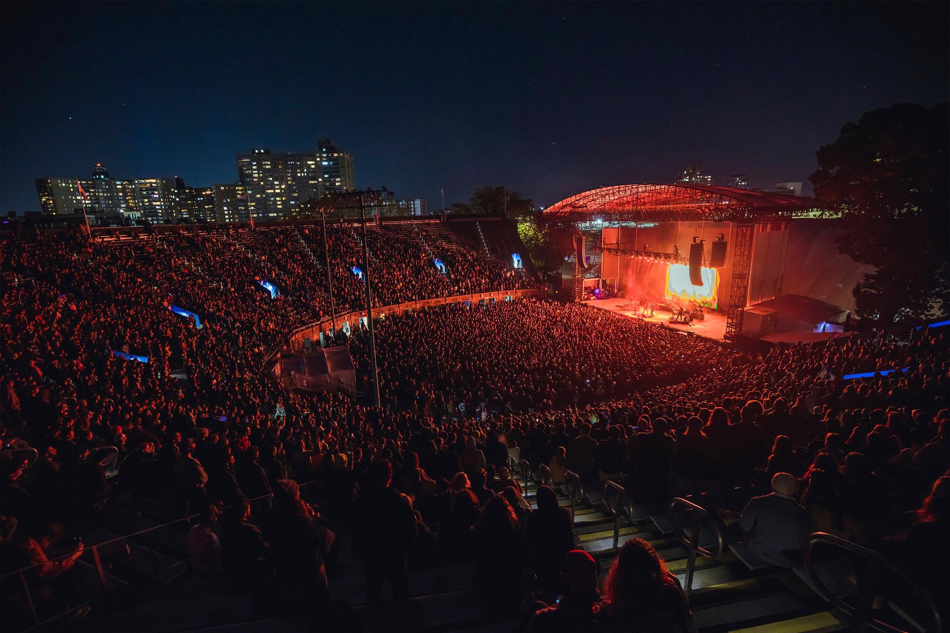 a large crowd of people at a concert at night in a stadium