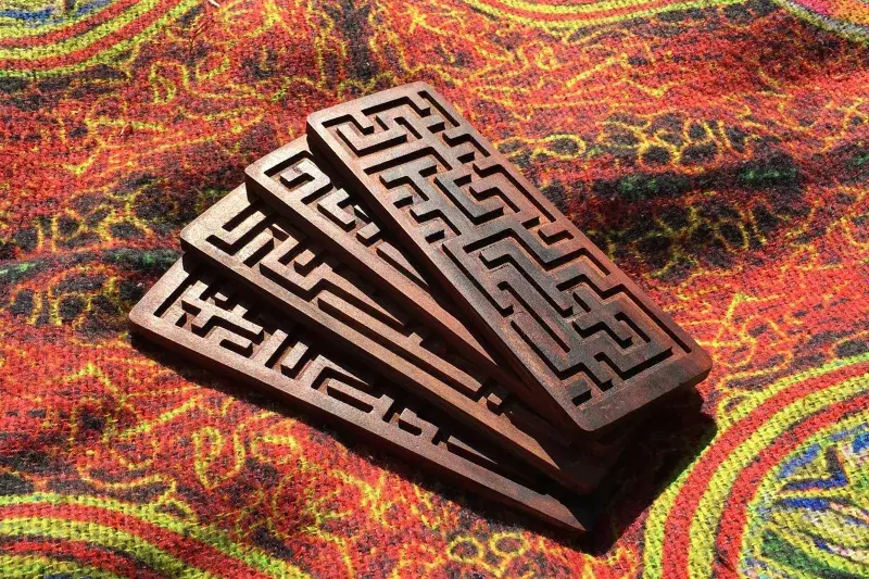 four pieces of carved wood sitting on top of a rug.
