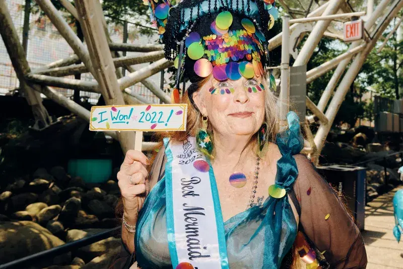 Person holding up sign indicating that she is a winner of 2022 Mermaid Parade, in Coney Island, Brooklyn